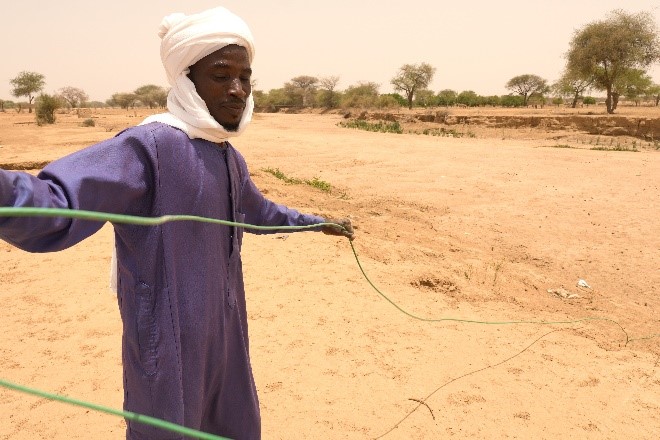 Two Sudanese refugees helping reel in ERT cable at the newly constructed Dougui Refugee Camp.