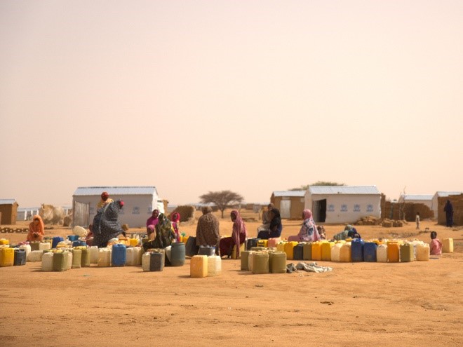 Sudanese refugee women waiting with their empty 20-liter jerry cans for a tap stand to flow at the Iridimi Refugee Camp.